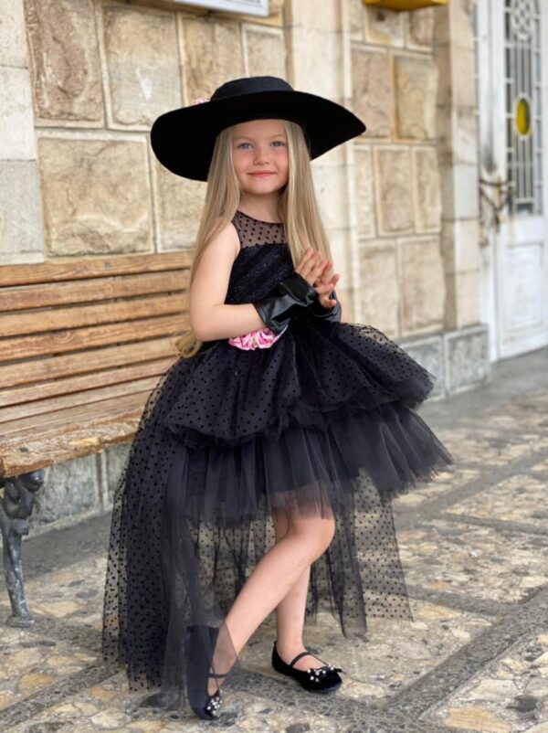 Девочка в черном платье со шлейфом и шляпе